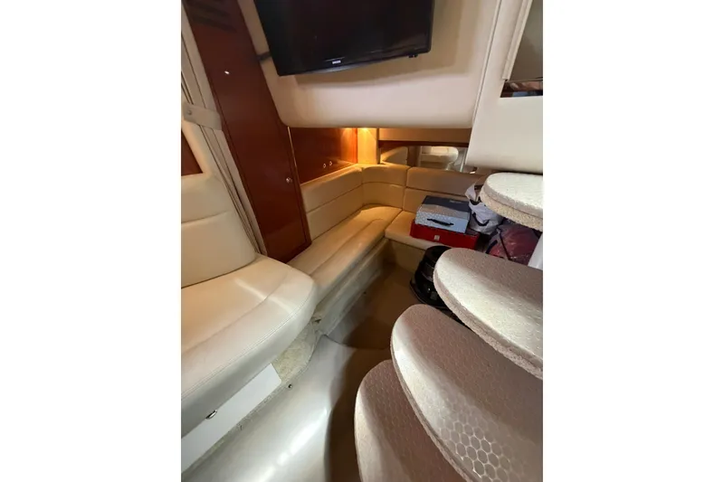 Slide: The Image of Interior of 2004 Sea Ray Sundancer 320 yacht with beige seating and a mounted TV. - 18