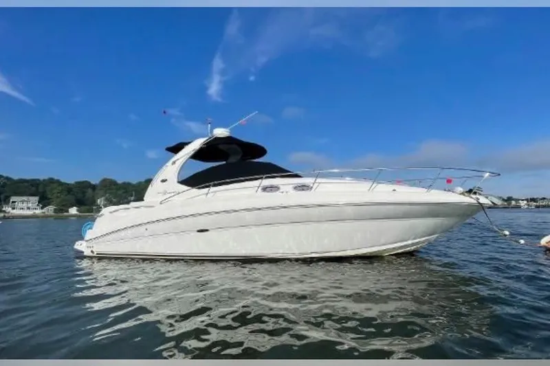 The Image of 2004 Sea Ray Sundancer 320 yacht on calm water under clear blue sky. - 0