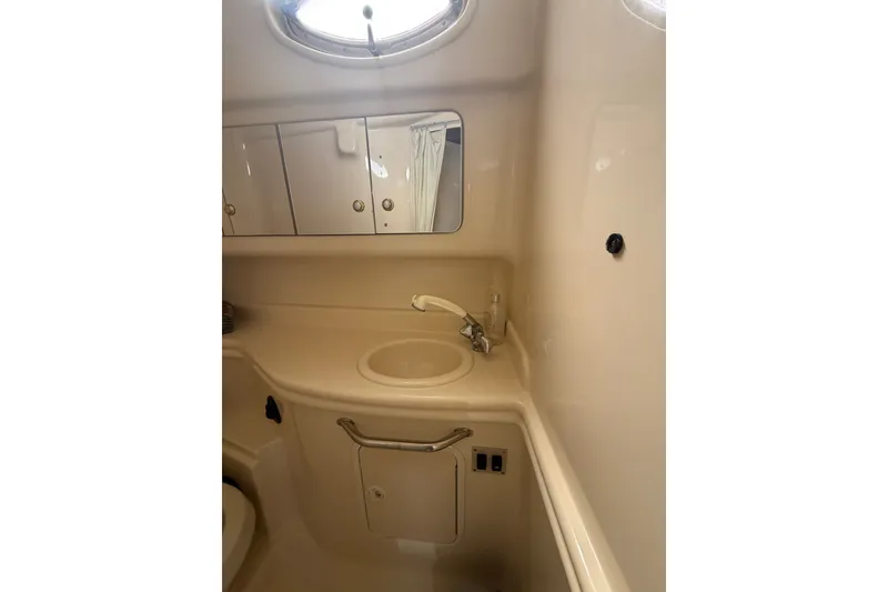 Slide: The Image of 2004 Sea Ray Sundancer 320 bathroom with sink, mirror, and storage cabinets. - 26