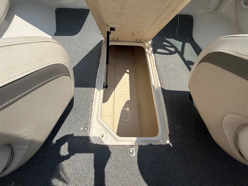 Slide: The Image of An open storage compartment in the floor of a boat, surrounded by cushioned seats. - 17