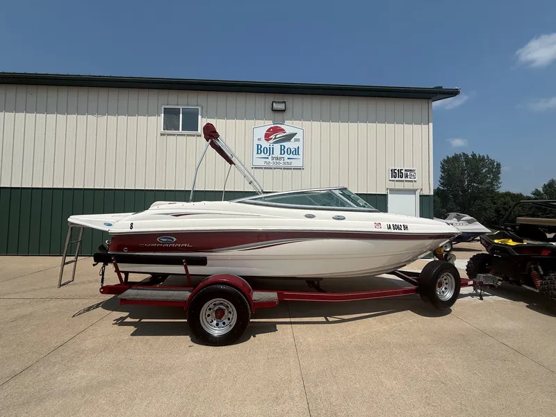 The Image of A 2005 Chaparral 190 SSi boat on a red trailer in front of a building. - 0