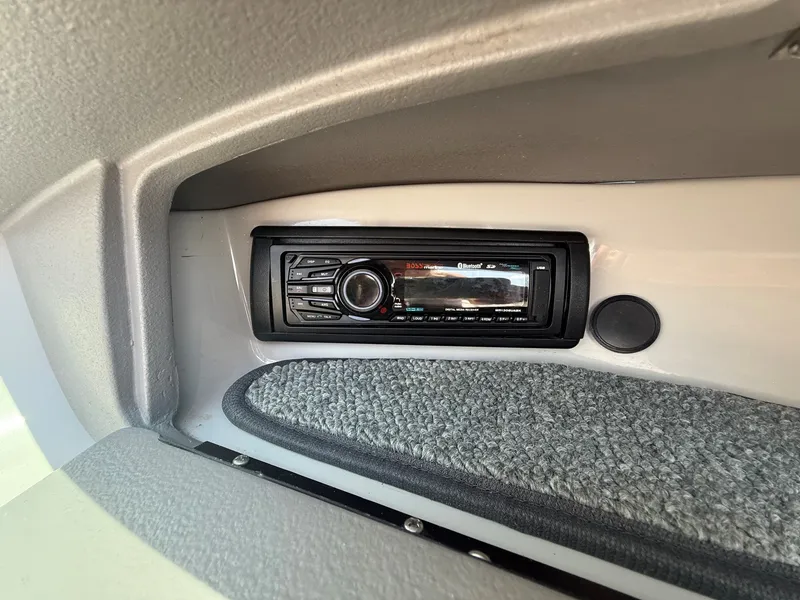 Slide: The Image of A built-in audio system on a boat with gray carpeting. - 16