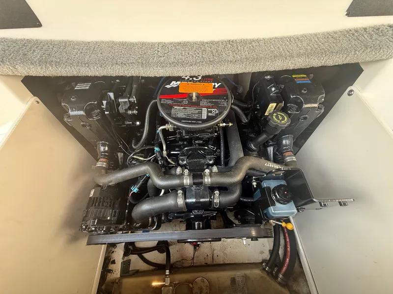 Slide: The Image of The engine compartment of a 2005 Chaparral 190 SSi shows a well-maintained engine with hoses and cables. - 18