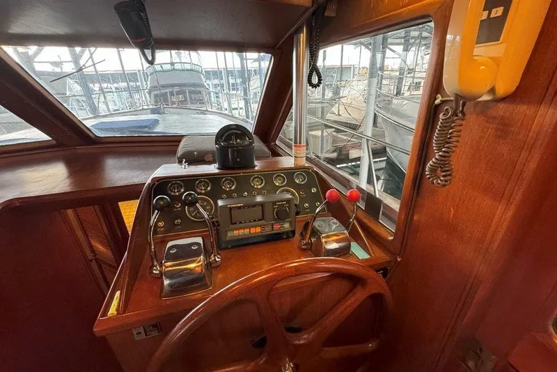 Slide: The Image of 1983 Ocean Alexander 40 Europa helm with classic wooden steering wheel and control panel. - 14