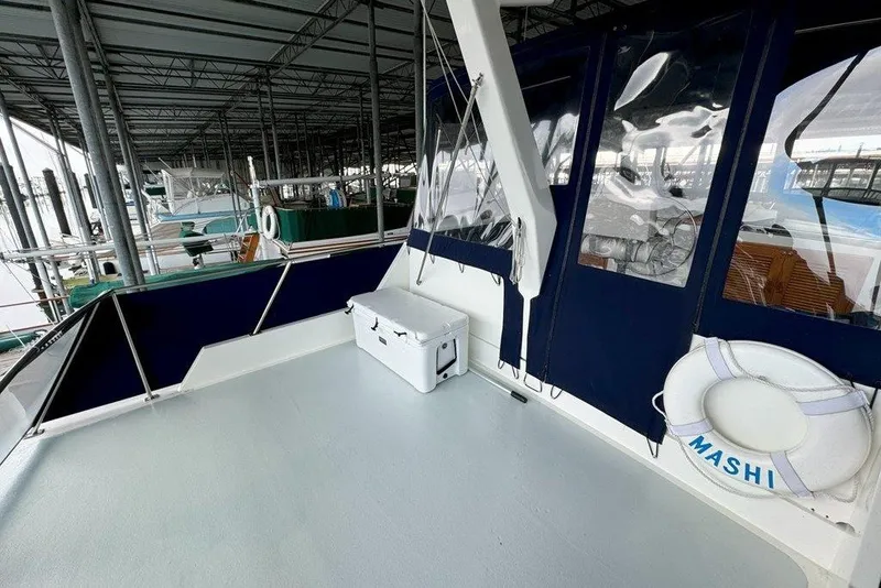 Slide: The Image of 1983 Ocean Alexander 40 Europa yacht deck with cooler and life preserver in marina. - 38