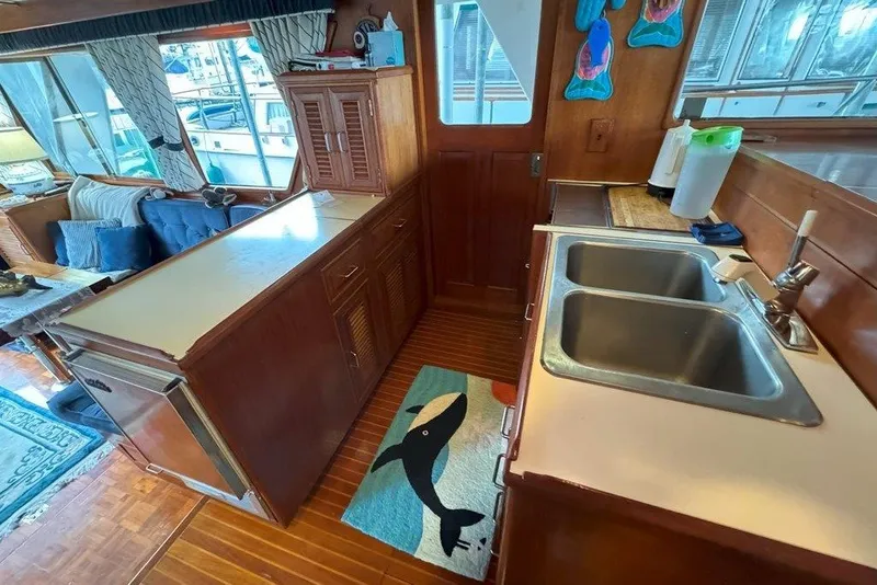 Slide: The Image of Interior of 1983 Ocean Alexander 40 Europa yacht, featuring kitchen sink and cozy seating area. - 9