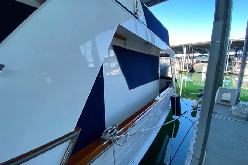 Slide: The Image of 1983 Ocean Alexander 40 Europa yacht docked in marina, side view with blue covers. - 52