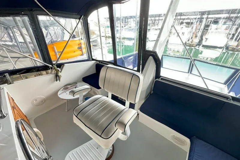 Slide: The Image of Interior view of 1983 Ocean Alexander 40 Europa yacht with seating and marina backdrop. - 45