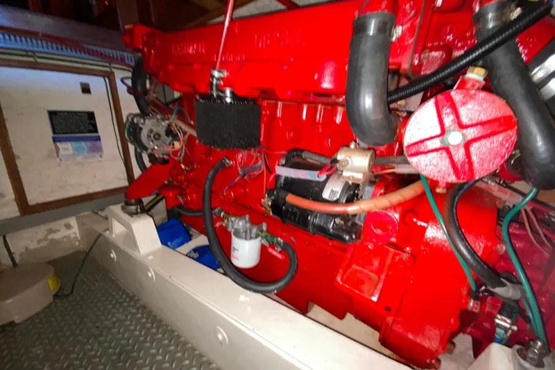 Slide: The Image of Engine compartment of 1983 Ocean Alexander 40 Europa, featuring a vibrant red engine. - 64