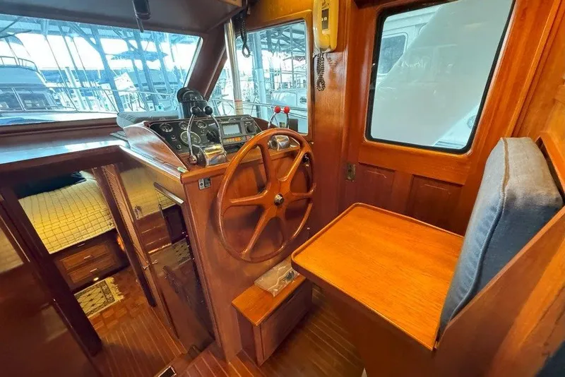 Slide: The Image of 1983 Ocean Alexander 40 Europa helm with wooden steering wheel and navigation instruments. - 13