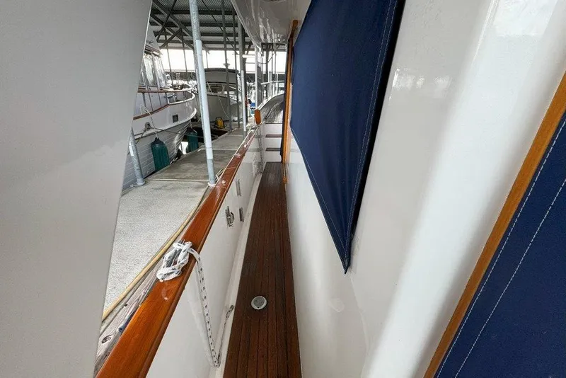 Slide: The Image of Side deck of 1983 Ocean Alexander 40 Europa yacht with wooden railings and blue canvas. - 29