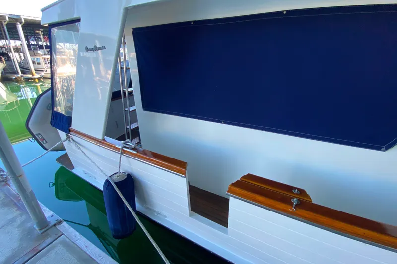 Slide: The Image of 1983 Ocean Alexander 40 Europa yacht docked, featuring blue canvas and wooden accents. - 47