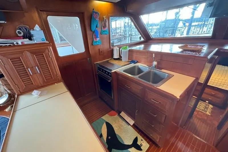 Slide: The Image of Interior of 1983 Ocean Alexander 40 Europa yacht kitchen with wooden cabinetry and dual sink. - 8