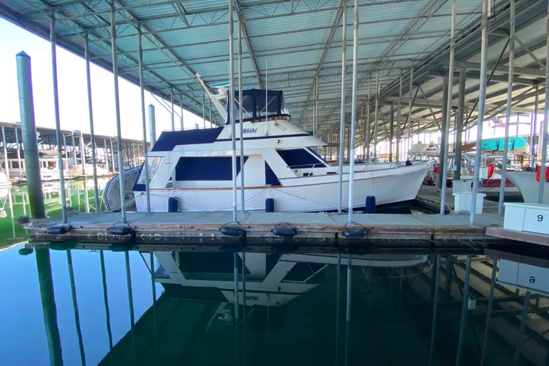 Slide: The Image of 1983 Ocean Alexander 40 Europa yacht docked in a covered marina. - 1