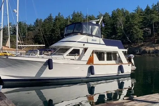 Slide: The Image of 1983 Ocean Alexander 40 Europa yacht docked in a serene marina setting. - 56