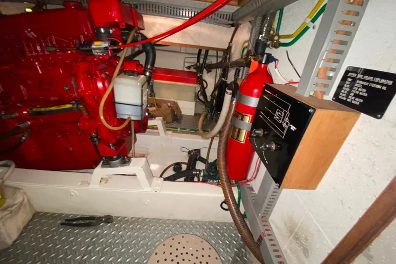 Slide: The Image of Engine room of 1983 Ocean Alexander 40 Europa with red engine and fire extinguisher. - 65