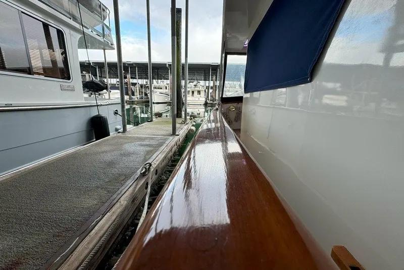 Slide: The Image of 1983 Ocean Alexander 40 Europa yacht docked at marina, showcasing polished wood railing. - 37