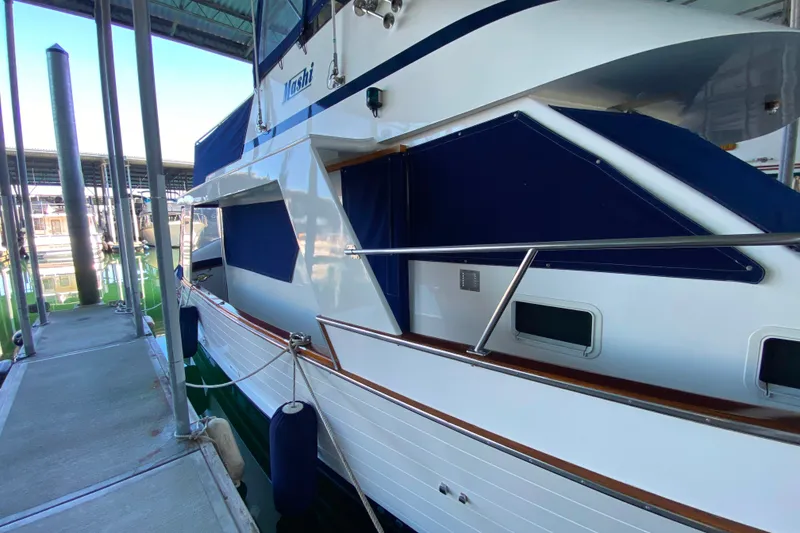 Slide: The Image of 1983 Ocean Alexander 40 Europa yacht docked, featuring sleek design and blue accents. - 48
