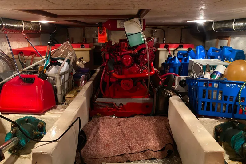 Slide: The Image of Engine room of 1983 Ocean Alexander 40 Europa, featuring red engine and storage items. - 61
