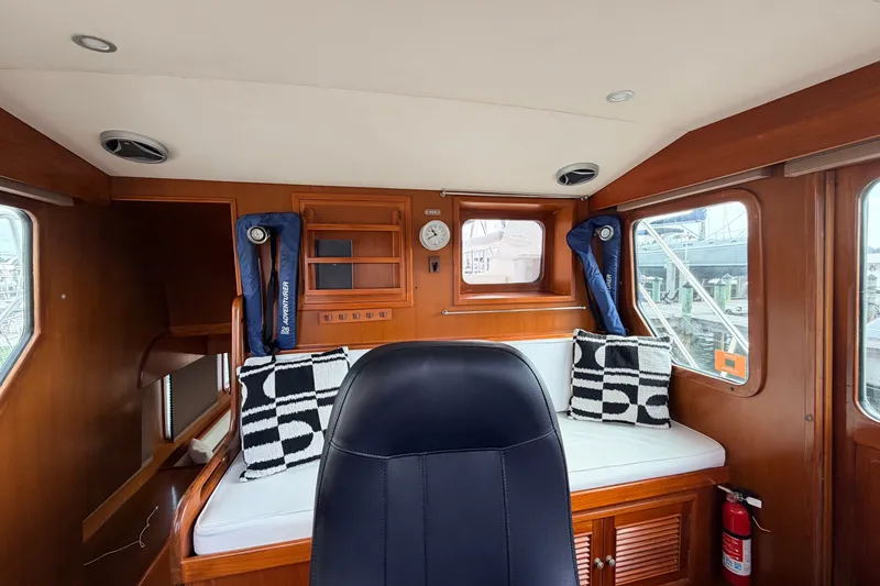 Slide: The Image of Interior of 2005 North Pacific 42 boat with seating, cushions, and wooden paneling. - 30