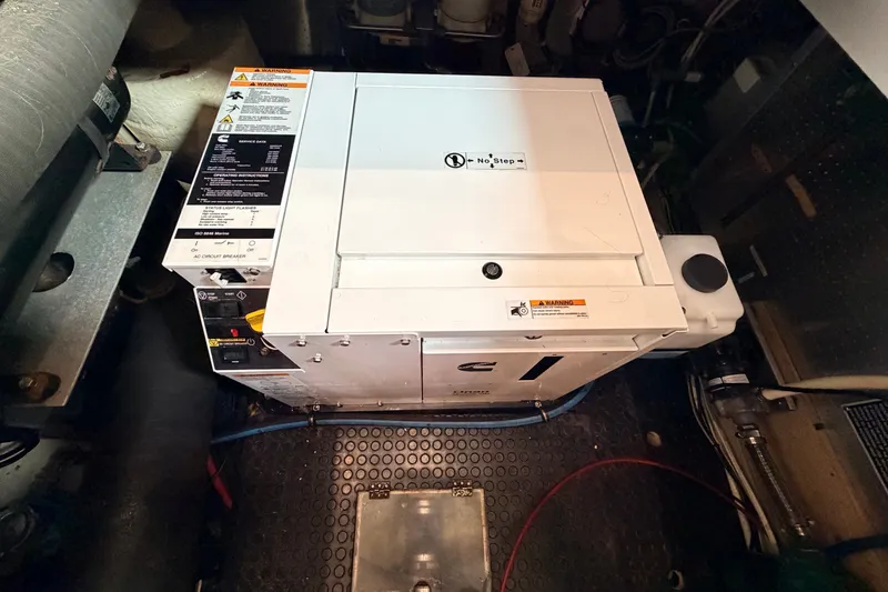 Slide: The Image of Engine room of a 2005 North Pacific 42 boat featuring a Cummins generator. - 68
