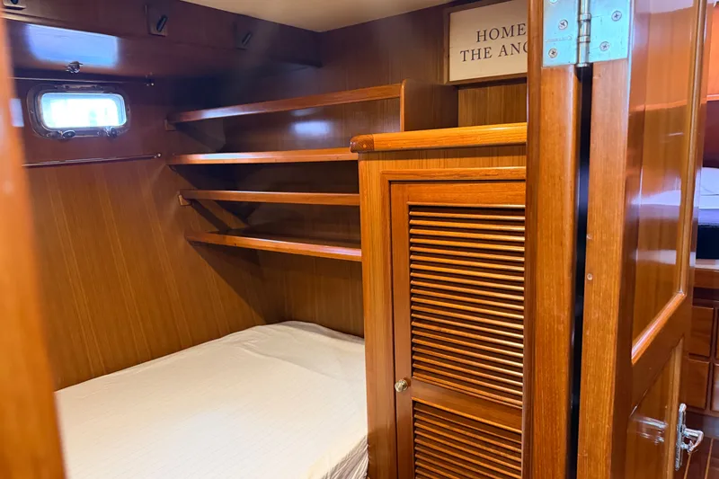 Slide: The Image of Cozy cabin interior of 2005 North Pacific 42 yacht with wooden shelves and bed. - 38