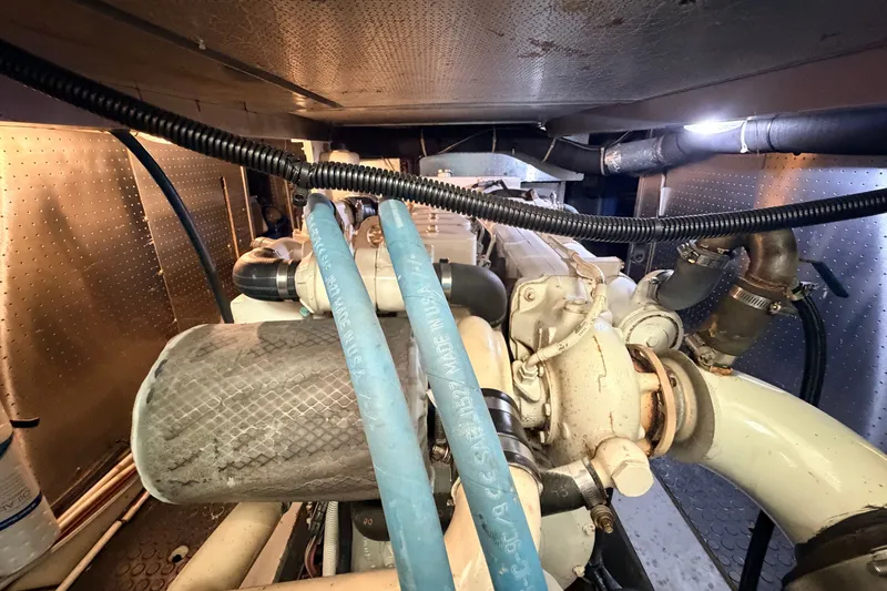 Slide: The Image of Engine room of a 2005 North Pacific 42 boat, showcasing mechanical components and hoses. - 58