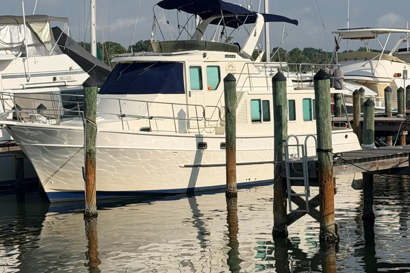 Slide: The Image of 2005 North Pacific 42 yacht docked at marina, featuring blue canopy and white hull. - 53