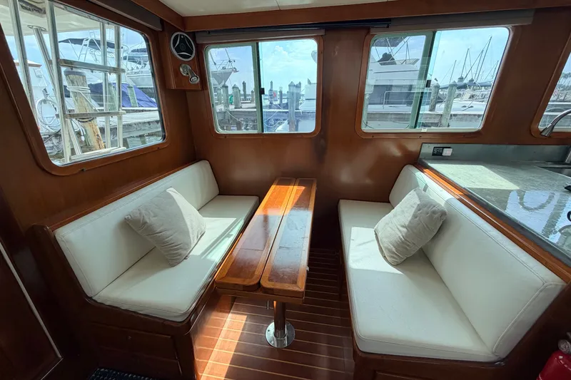 Slide: The Image of Cozy interior of 2005 North Pacific 42 yacht with cushioned seating and wooden table. - 18