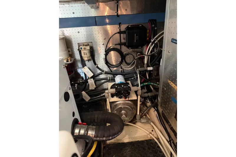 Slide: The Image of Engine room of a 2005 North Pacific 42 boat, showcasing mechanical components and wiring. - 65