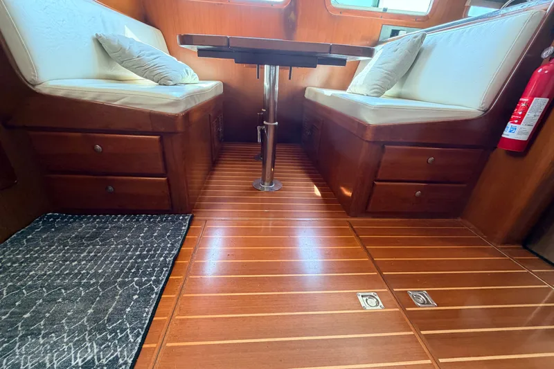 Slide: The Image of Interior of 2005 North Pacific 42 boat with wooden flooring and cushioned seating. - 25