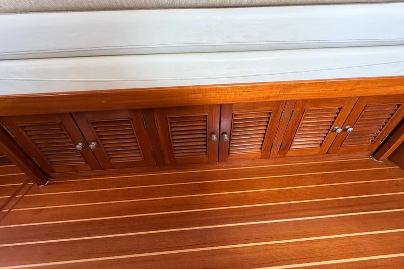 Slide: The Image of Wooden interior of a 2005 North Pacific 42 boat, featuring louvered cabinets and striped flooring. - 24
