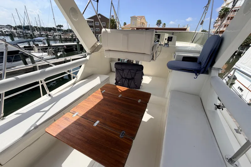 Slide: The Image of Flybridge of 2005 North Pacific 42 yacht with seating and wooden table, docked at marina. - 45