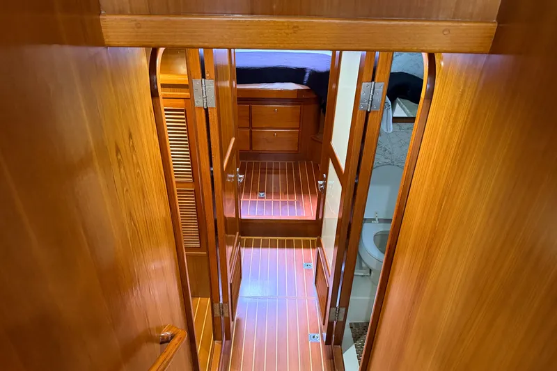 Slide: The Image of Wood-paneled hallway inside 2005 North Pacific 42 yacht, featuring bedroom and bathroom access. - 31