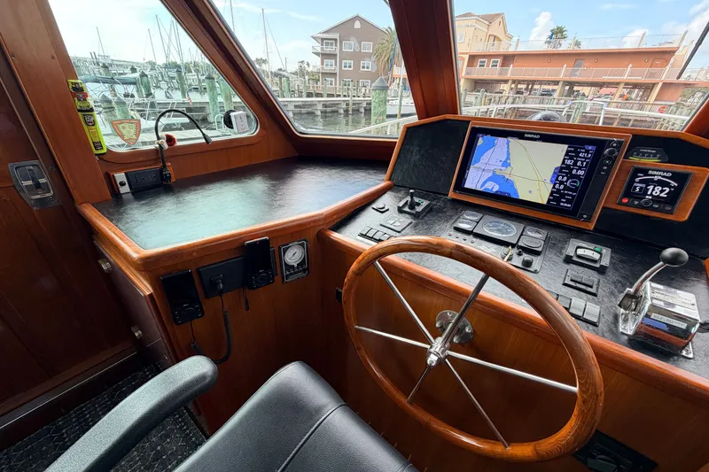 Slide: The Image of Pilothouse of 2005 North Pacific 42 yacht with navigation equipment and wooden steering wheel. - 27