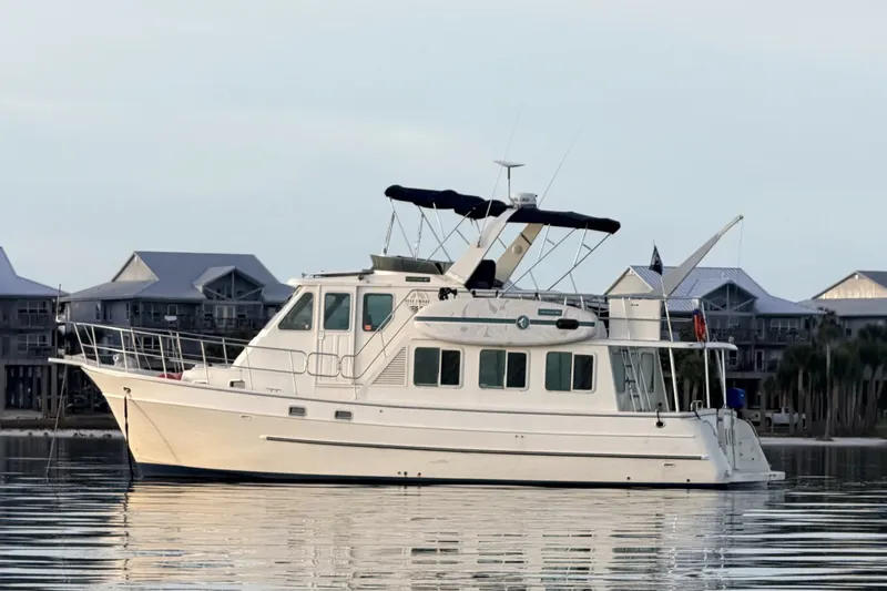 The Image of 2005 North Pacific 42 yacht on calm water near coastal homes. - 0
