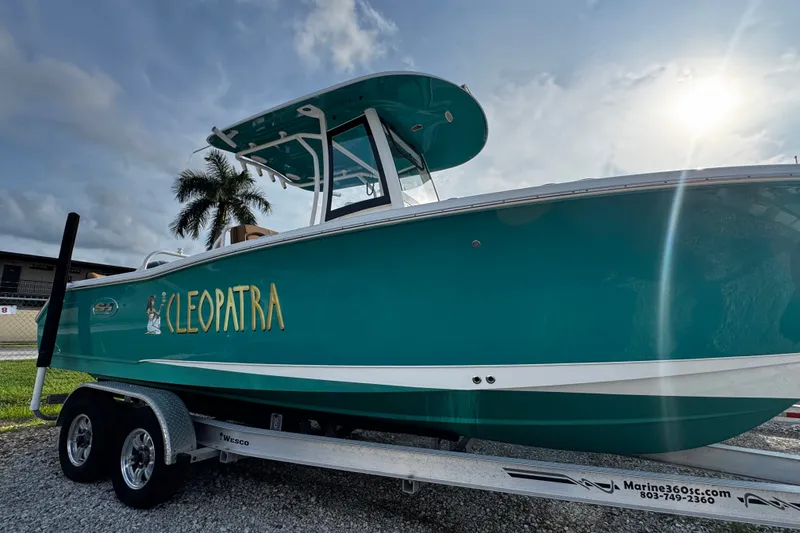 The Image of 2021 Sea Hunt Ultra 255SE boat named Cleopatra on trailer under sunny sky. - 0