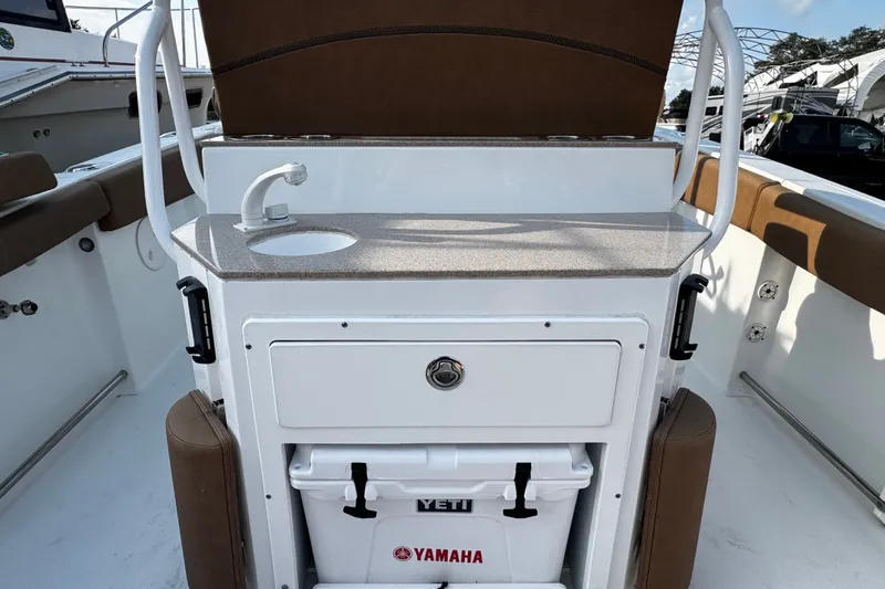 Slide: The Image of 2021 Sea Hunt Ultra 255SE boat interior with sink, storage, and Yeti cooler. - 13