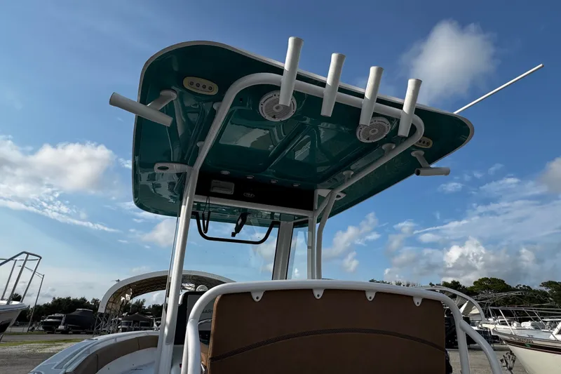 Slide: The Image of 2021 Sea Hunt Ultra 255SE boat with T-top and rod holders under a clear blue sky. - 15