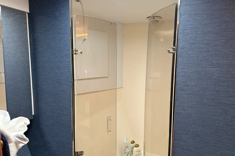 Slide: The Image of Shower area inside 2002 Ocean Yachts 56 Super Sport, featuring blue walls and toiletries. - 30