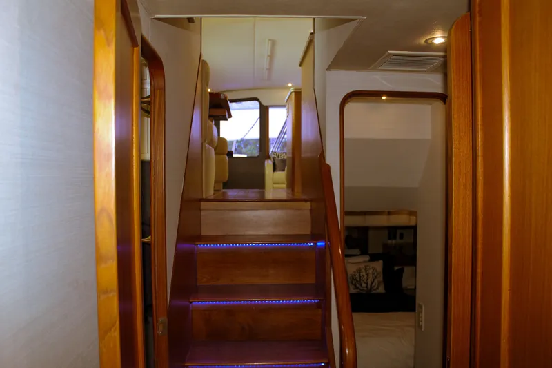 Slide: The Image of Interior view of 2002 Ocean Yachts 56 Super Sport, featuring wooden stairs and cozy seating area. - 29