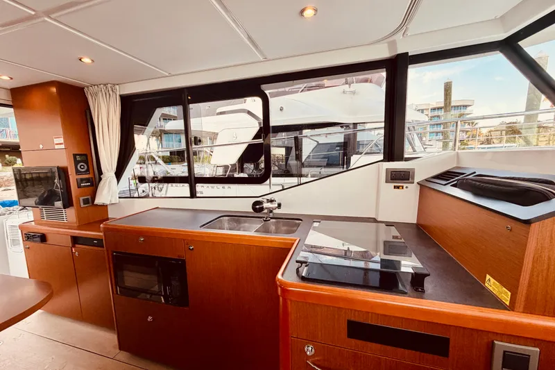 Slide: The Image of Interior of 2019 Beneteau Swift Trawler 30, featuring modern kitchen and large windows. - 16
