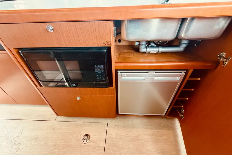 Slide: The Image of 2019 Beneteau Swift Trawler 30 kitchen with microwave, sink, and compact fridge. - 17