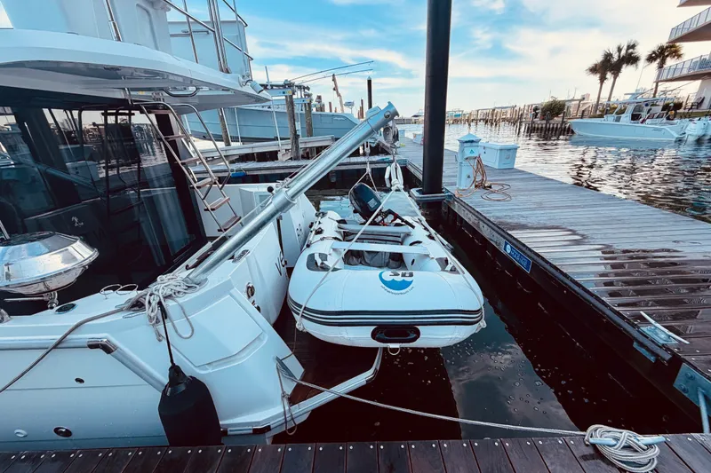 Slide: The Image of 2019 Beneteau Swift Trawler 30 docked with inflatable dinghy, marina setting. - 5