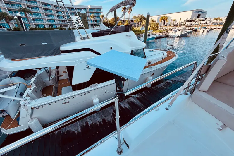 Slide: The Image of 2019 Beneteau Swift Trawler 30 docked at marina, surrounded by water and nearby boats. - 8