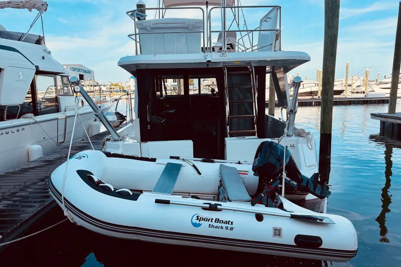 Slide: The Image of 2019 Beneteau Swift Trawler 30 docked with inflatable boat, marina background. - 3