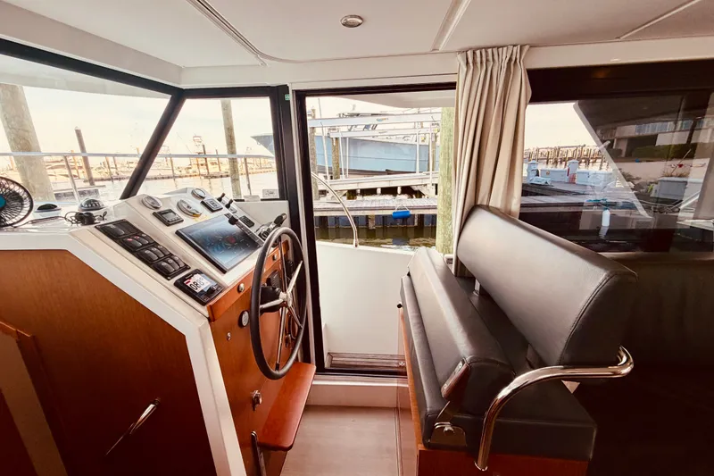 Slide: The Image of Interior helm of 2019 Beneteau Swift Trawler 30, featuring modern controls and seating. - 15