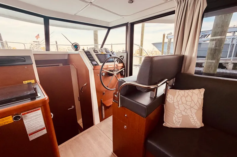 Slide: The Image of Interior of 2019 Beneteau Swift Trawler 30, featuring helm station and seating area. - 14