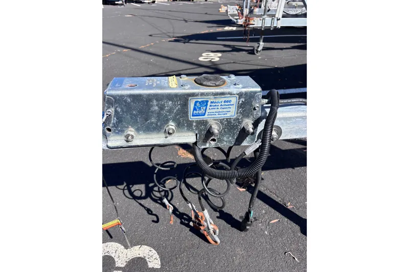 Slide: The Image of Trailer brake actuator model 660 with coiled cables on asphalt surface. - 25