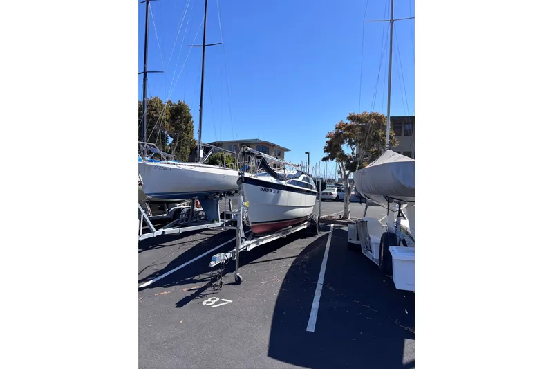 Slide: The Image of Sailboats parked on trailers in a marina lot under clear blue sky. - 16